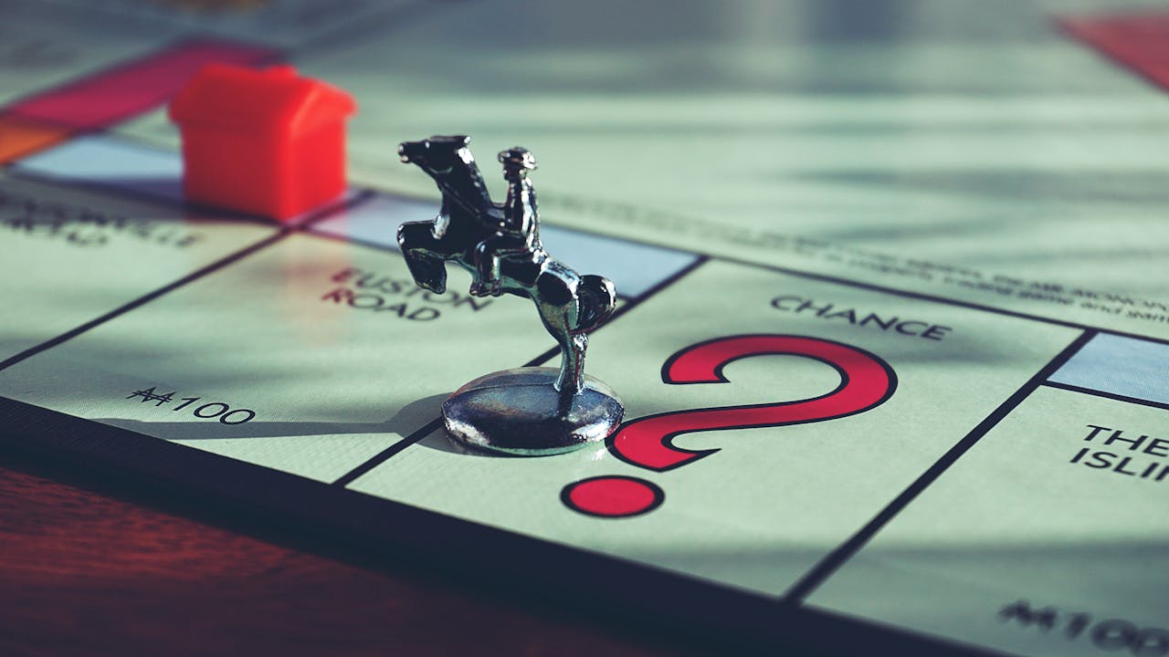 The Art of Drawing Readers In: Your attractive post title goes here Close-up of a Monopoly board with a token and house, capturing classic board game elements.